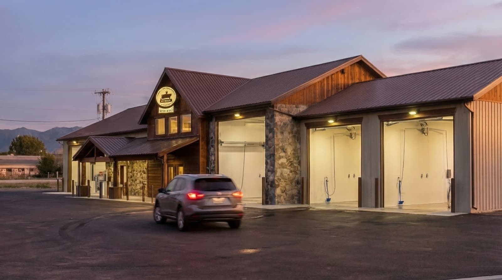 Self-serve wash bays at dusk with mountain backdrop